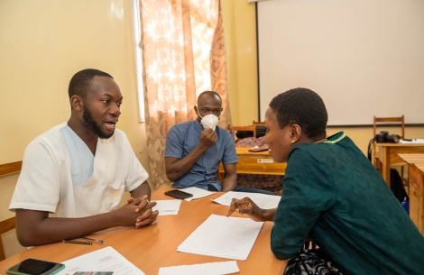 Faysal and Edouardo sitting at a table with a speech therapy patient