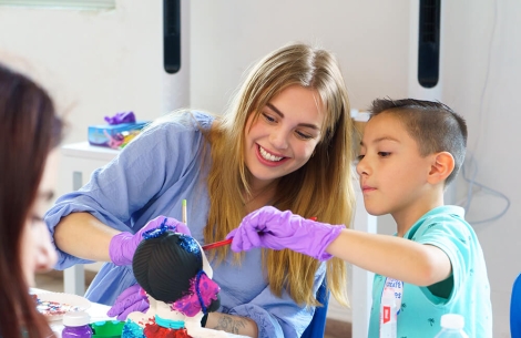 Smile Train member with patient painting together