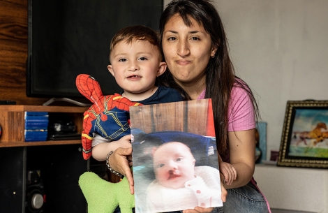Andrea holding Edden and a picture of him before cleft surgery