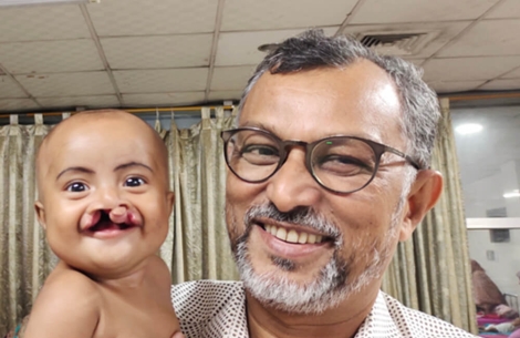 ABM Mobasher Hossain holding Smile Train patient baby