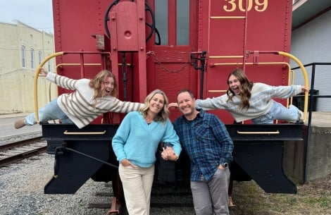 The Houghs standing on the back of a train