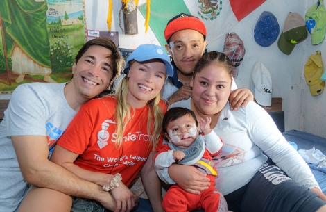 Justin Long and Kate Bosworth smiling and hugging Smile Train patients in Mexico