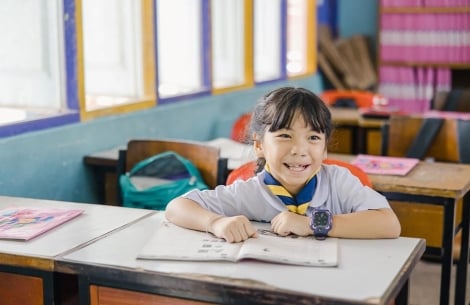 Pim smiling and studying in school after her cleft surgery