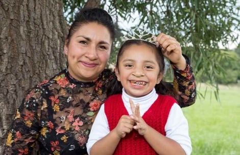 Leticia and Ivanna smile for the camera. Leticia holds a tiara above Ivanna’s head