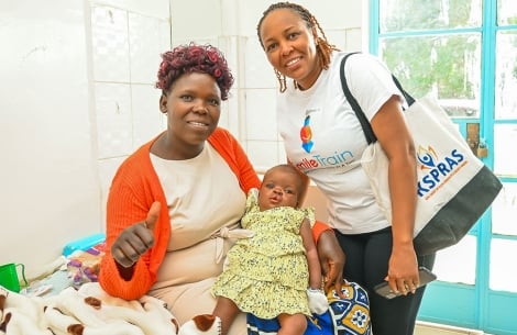 A mother with her baby and a Smile Train partner at a World Cleft Awareness Day event in Kenya