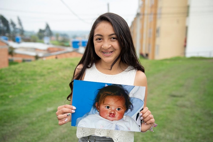 Monica holding an image of herself as a child