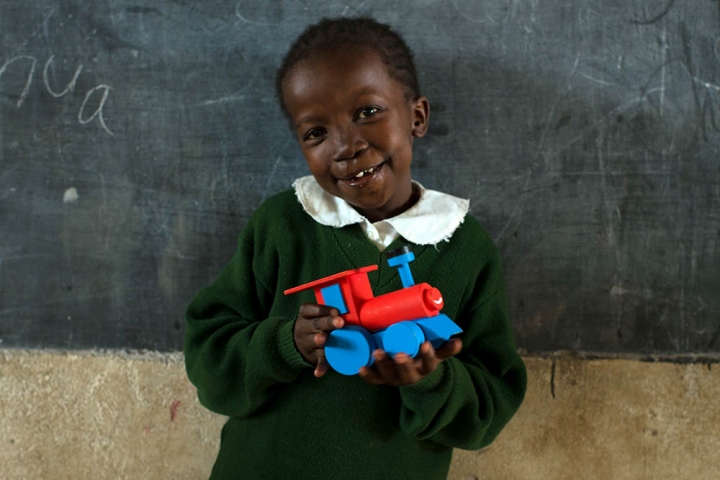 Girl holds a train in front of chalkboard