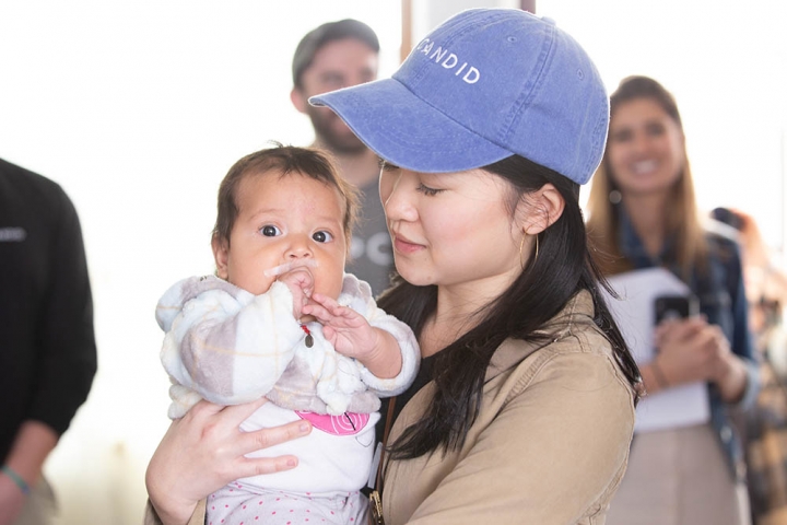 Corporate partner holds a child with cleft