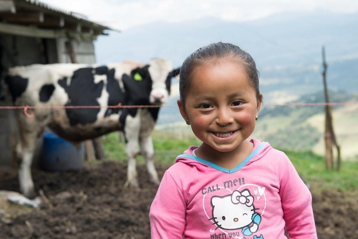 Fernanda stands in front of a cow