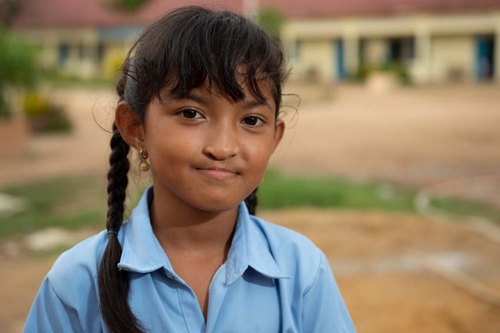 Samnang smiles in front of her school