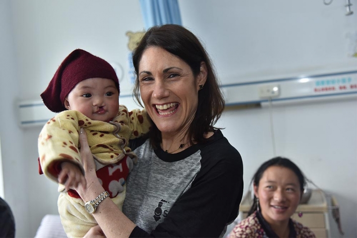 CEO Susannah Schaefer holds a child with cleft in China