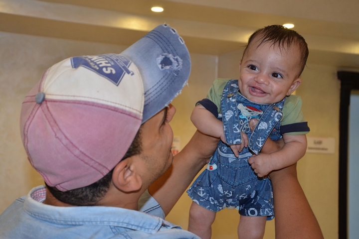 Saber being held by his father after his Smile Train cleft surgery