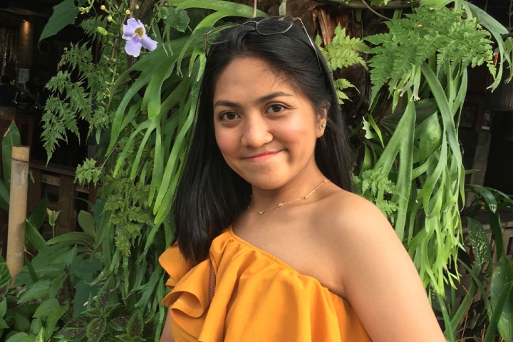 Jula smiling in front of some plants