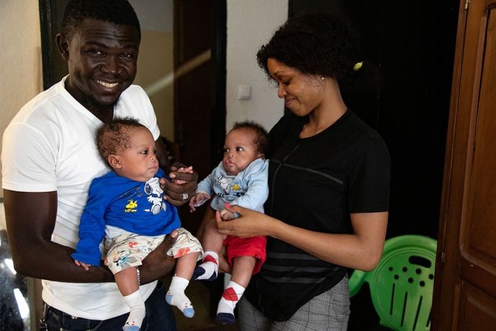 Audrey and Herve holding their twins, Lloyd and Floyd