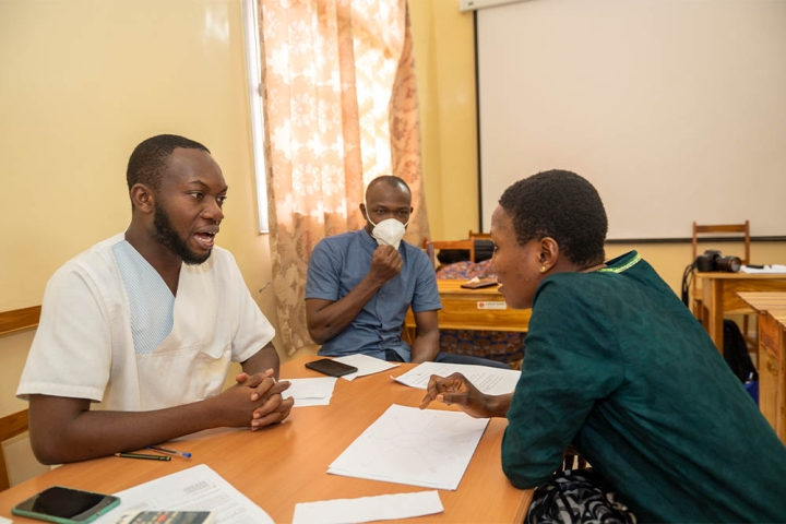 Faysal and Edouardo sitting at a table with a speech therapy patient