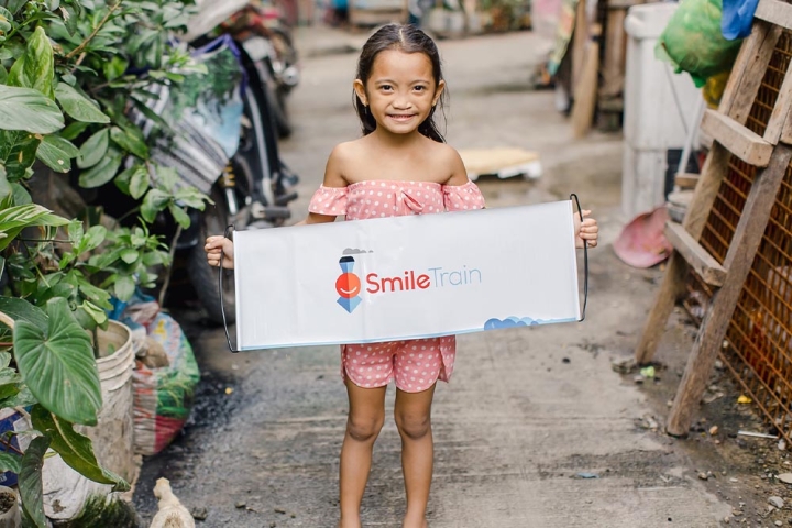 Leana holding a Smile Train banner