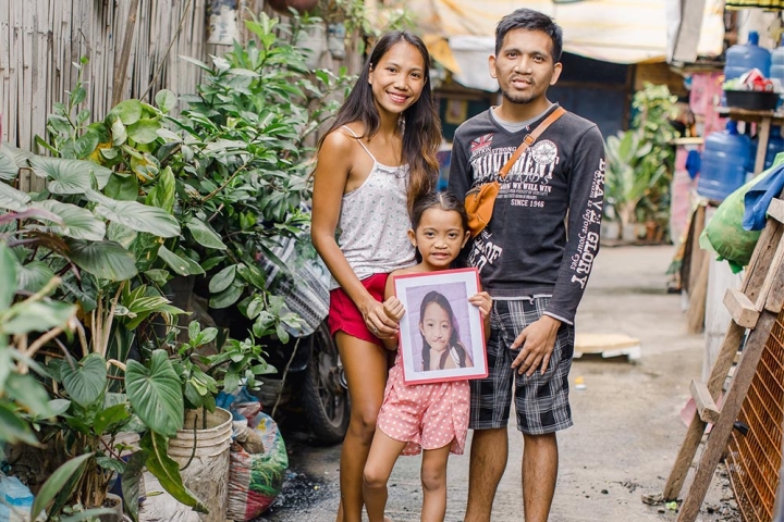Ranelyn and Leonardo holding Leana, showing a photo of her before surgery