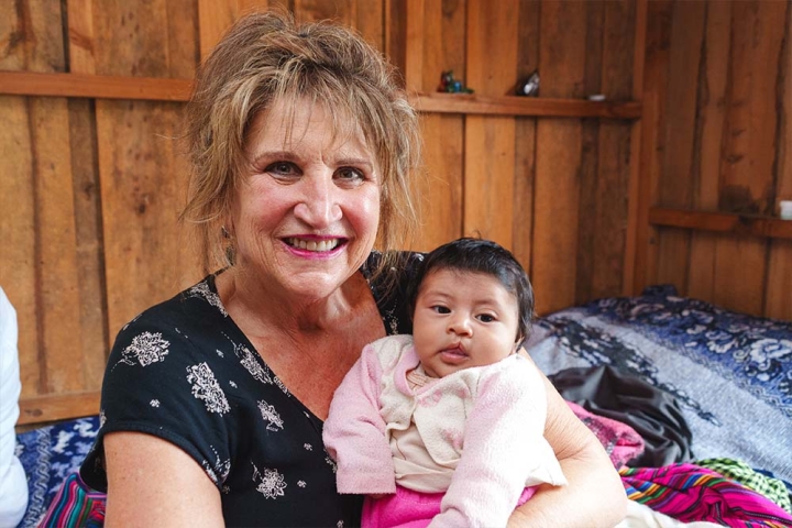 Sue Hoover smiling and holding a cleft-affected baby in Guatemala