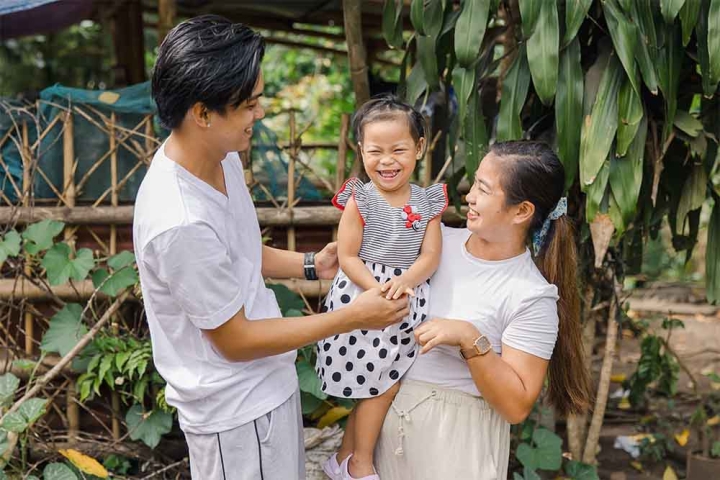 Kaylee smiling and hugging her parents Ken and Selma after cleft surgery