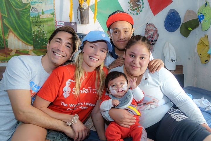 Justin Long and Kate Bosworth smiling and hugging Smile Train patients in Mexico