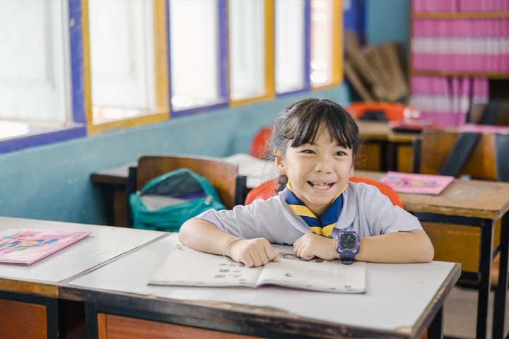 Pim smiling and studying in school after her cleft surgery