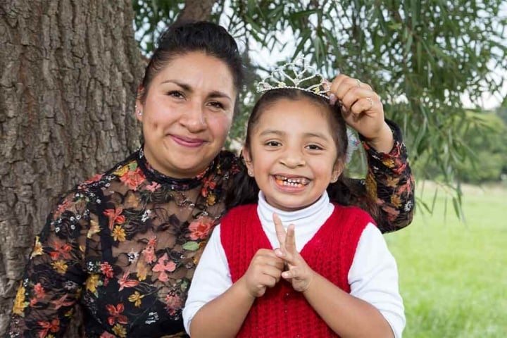 Leticia and Ivanna smile for the camera. Leticia holds a tiara above Ivanna’s head
