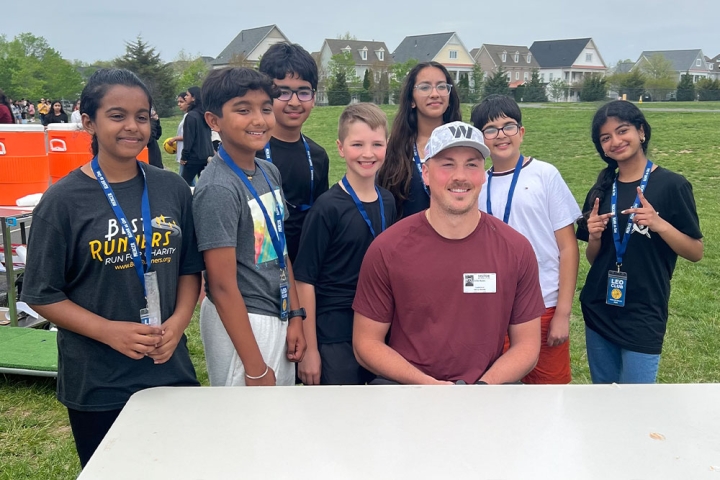 John Bates, tight end of the Washington Commanders, sharing a smile with members of the Leo Club