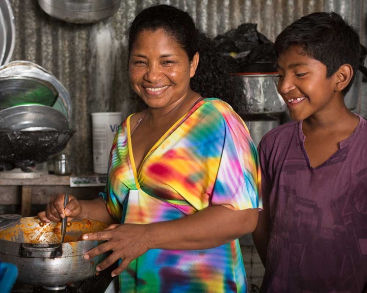 Smile Train patient looking at pot of mother's cooking