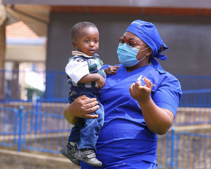 Dr. Amanda Malungo holding a cleft patient after his surgery.