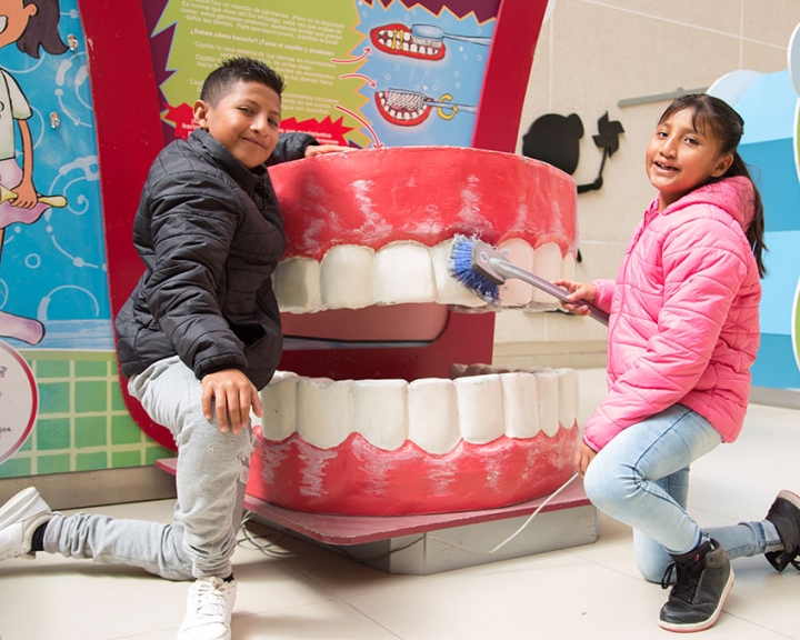 Alex and Kendra demonstrate tooth brushing technique on a giant mouth
