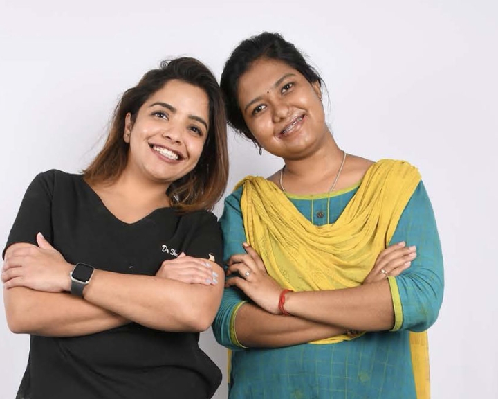 Dr. Shruti smiling and touching heads with a teenage patient