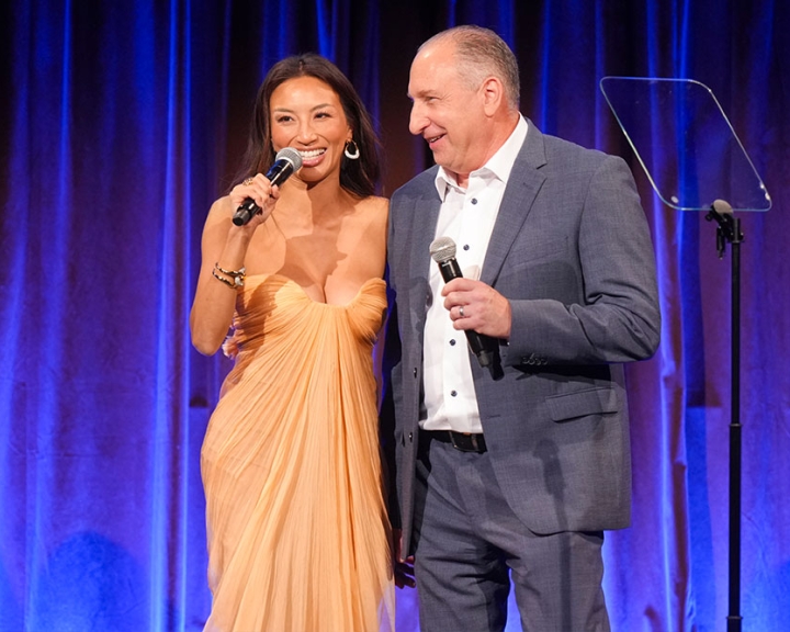 Jeannie Mai and Roy E. Reichbach share a moment on stage during Smile Train's 25th-Anniversary Gala