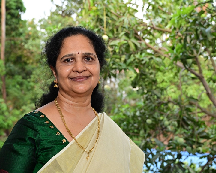 Shoba Lonappan in a forested setting wearing a sari