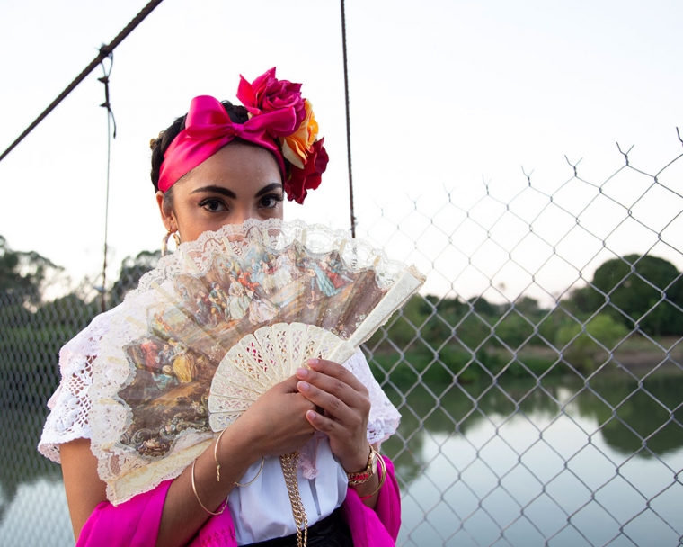 Adahara holding a traditional Mexican fan over her mouth.