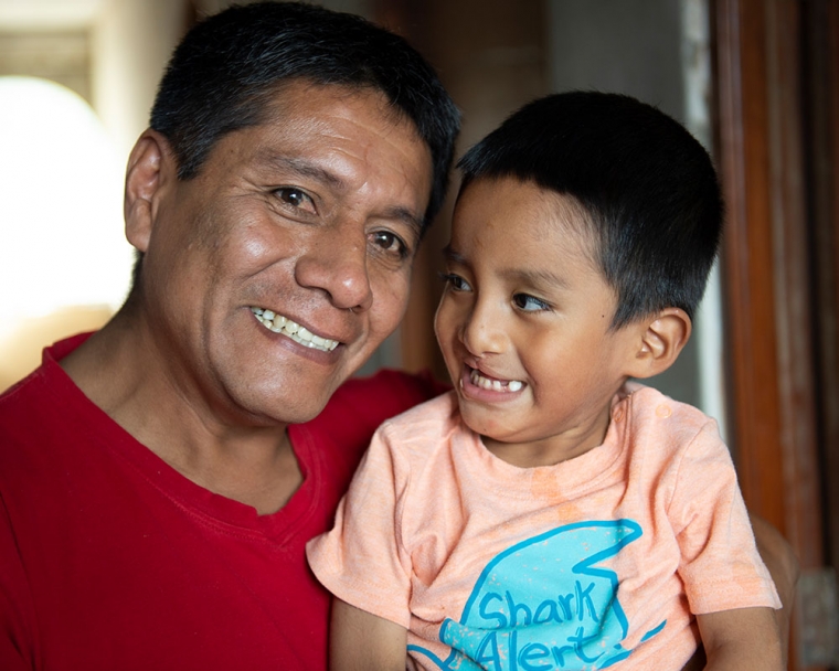 Anghelo smiling with his dad after free cleft lip and palate treatment in Peru.