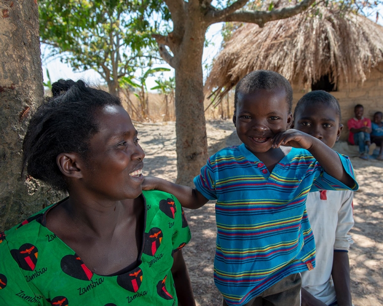 Oscar with his mother outside in their village in Zambia after his free Smile Train-sponsored cleft treatment.