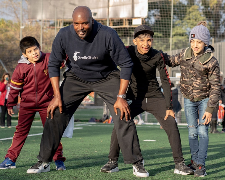 Mathias showing football clinic participants how to stand