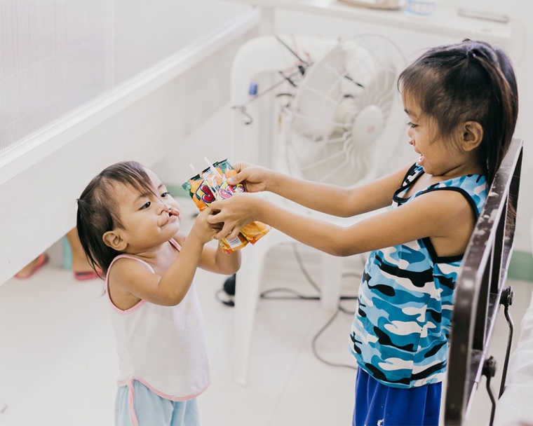 Ernie and Ermalen sharing a juice box before their cleft surgeries