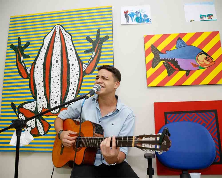 Artist Renan Andrade sings a song with his guitar