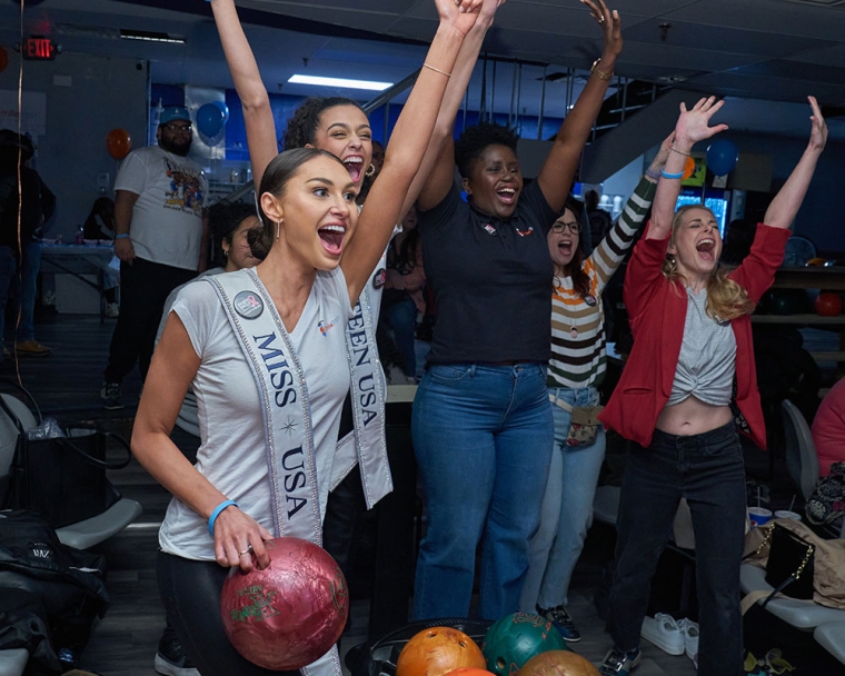Miss USA cheering and holding a bowling ball with CCAC