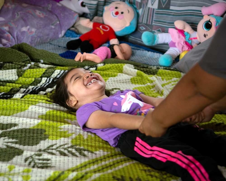 Itzayana playing on her bed after cleft surgery