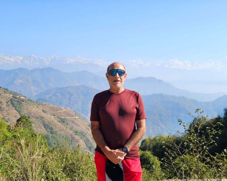 Sunil Tuli standing on a mountaintop