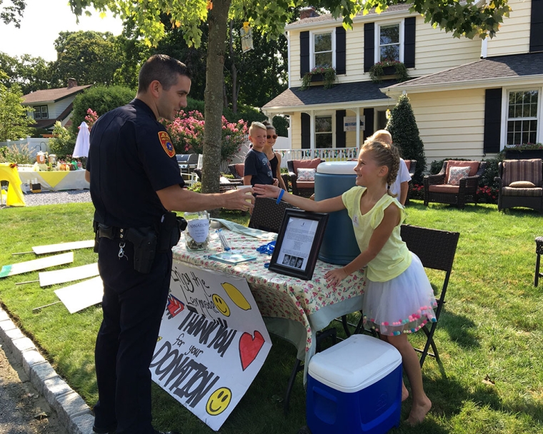 Ella smiling and selling lemonade