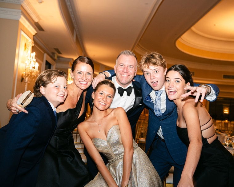 Ella smiling with her family at her 16th birthday party