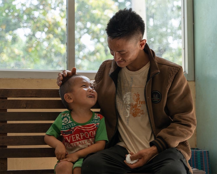 La Vang smiling and patting Jingtee on the head after his cleft surgery