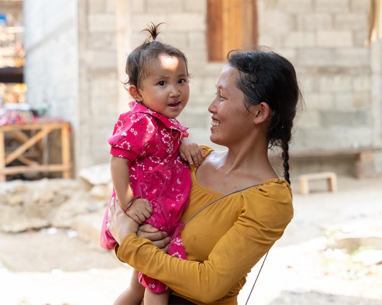 Ming Lao smiling and holding Nalee after her cleft surgery