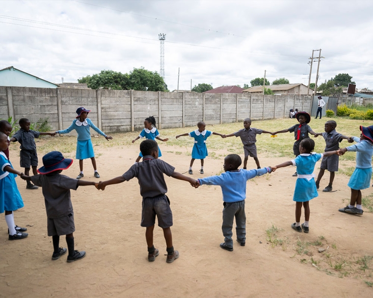 David with his classmates holding hands in a circle