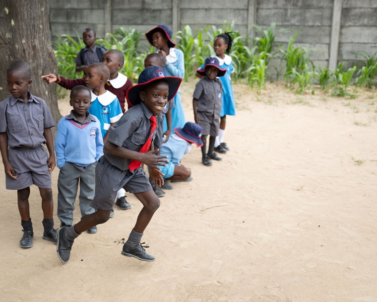David smiling and running with his classmates