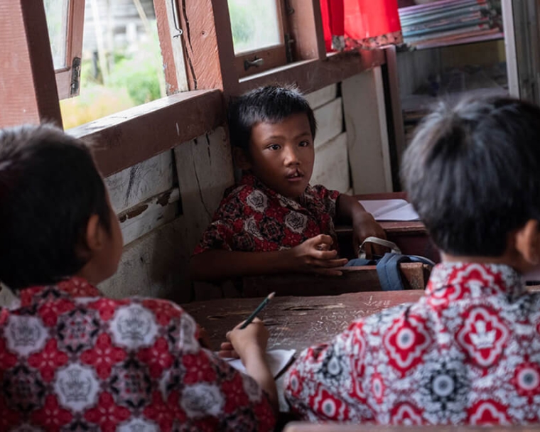 Rajib sitting in school before cleft surgery