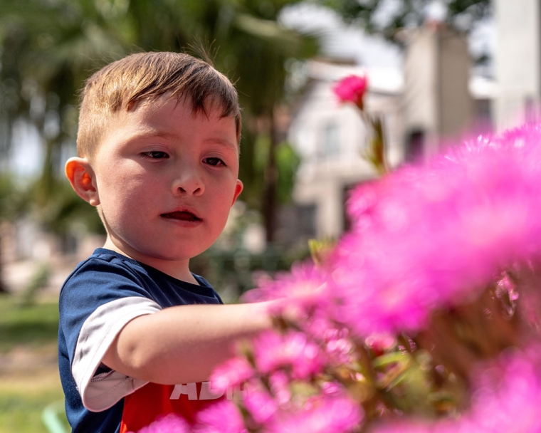 Edden picking a flower after cleft surgery
